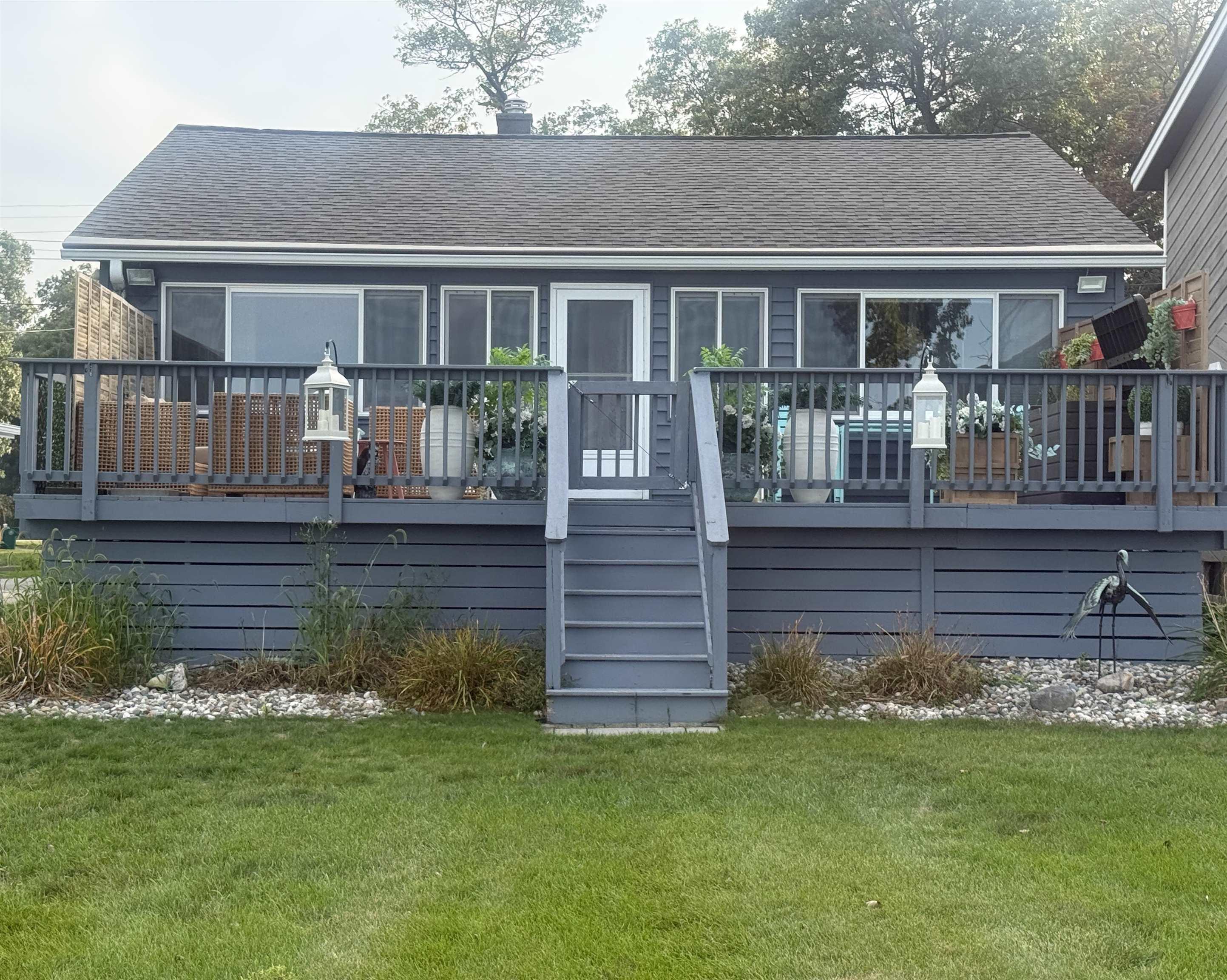 Image 0: This charming 2-bedroom, 1-bath beach house blends modern updates with a cozy, coastal feel. The main living space features bright, open interiors with large windows that frame sweeping views of the water., Front