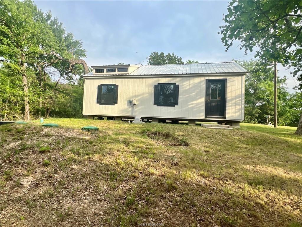 Image 3: Back of house with a yard and a metal roof