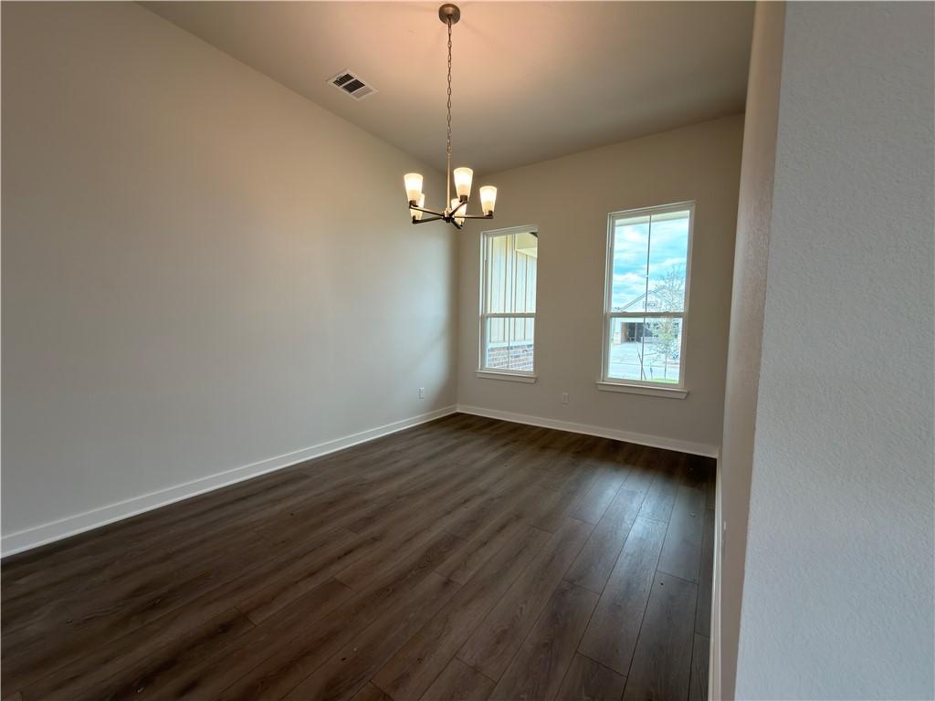 Image 3: Empty room with dark wood finished floors and a ch