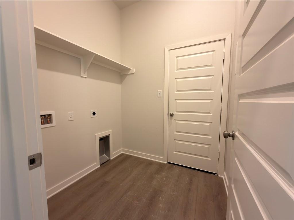 Image 4: Laundry area with dark wood-style flooring, electr