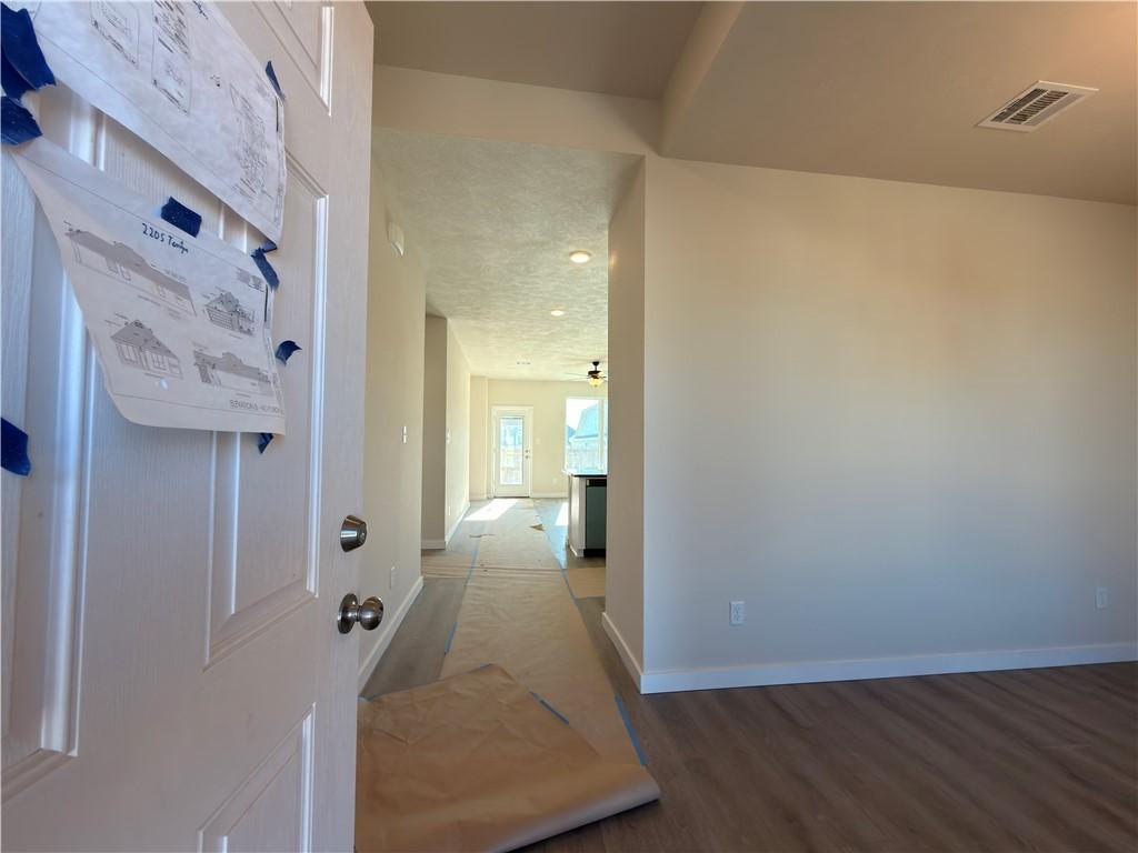 Image 2: Hall featuring dark wood-style floors and a textur