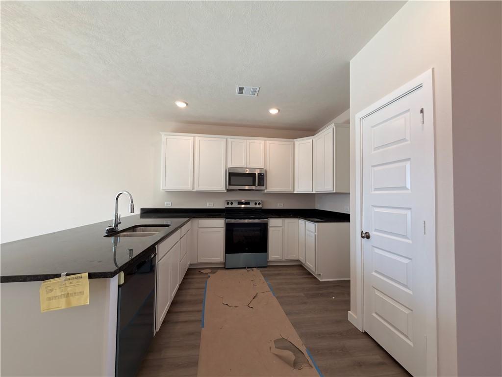 Image 3: Kitchen with stainless steel appliances, white cab