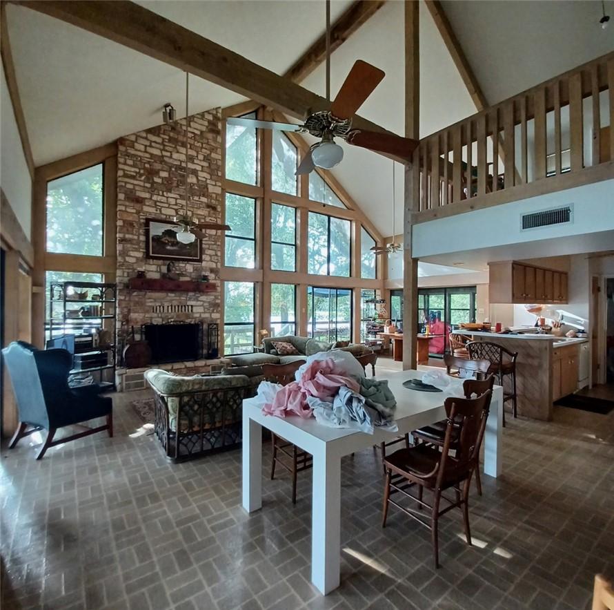 Image 4: Dining space featuring a stone fireplace, high vau