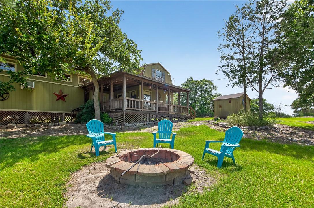 Image 2: View of grassy yard with an outdoor fire pit and a