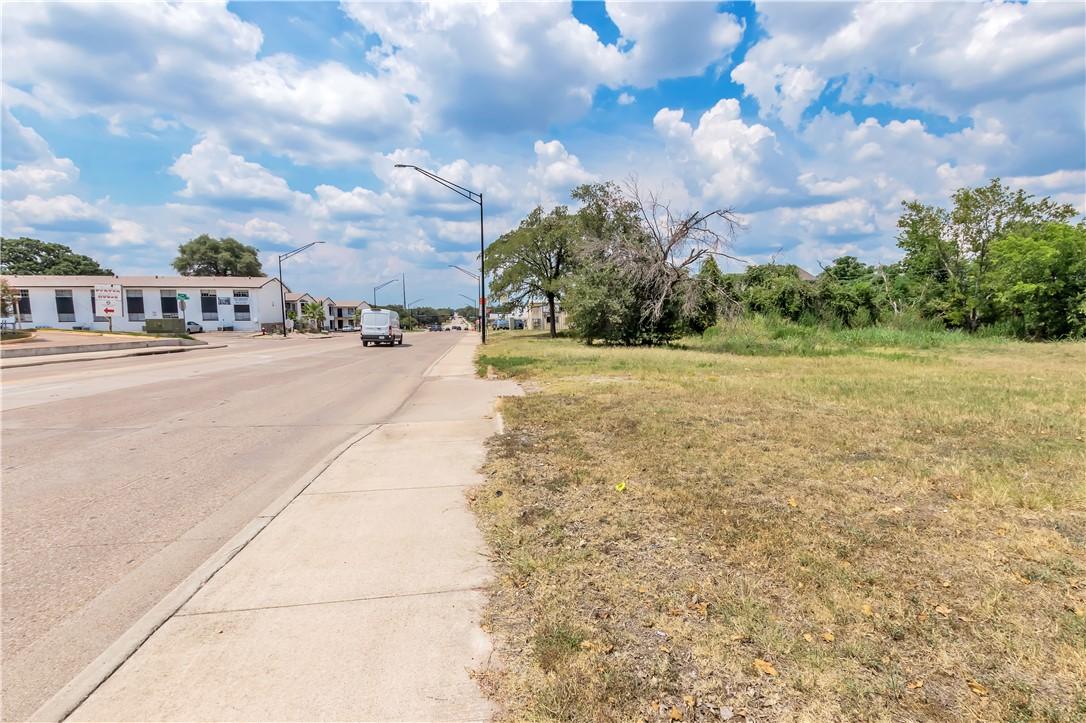 Image 2: View of asphalt road with sidewalks, street lights