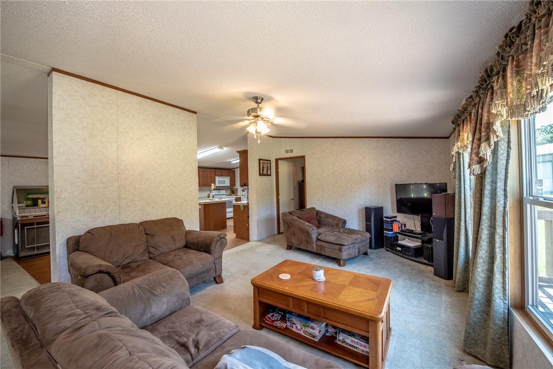 Image 4: Living room with a textured ceiling, a healthy amo