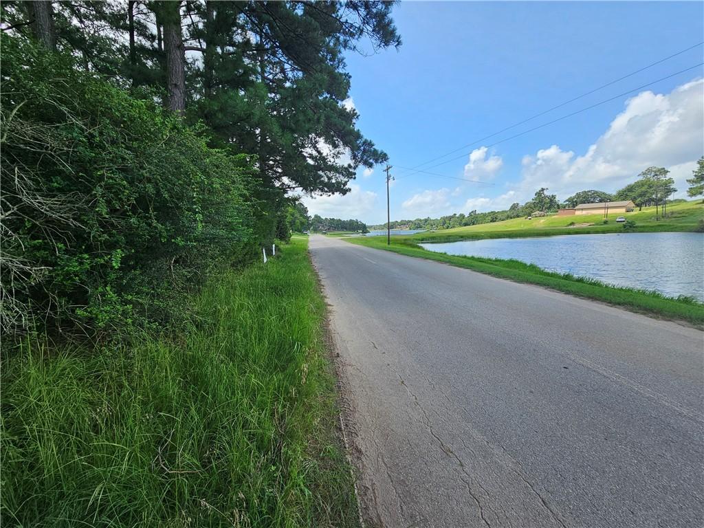 Image 1: View of asphalt road with a water view