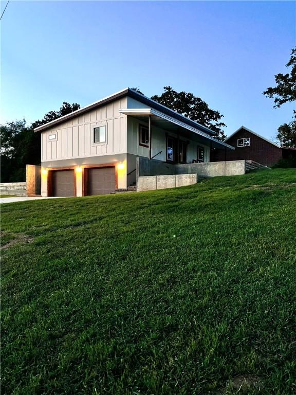 Image 1: View of side of home featuring a yard, an attached