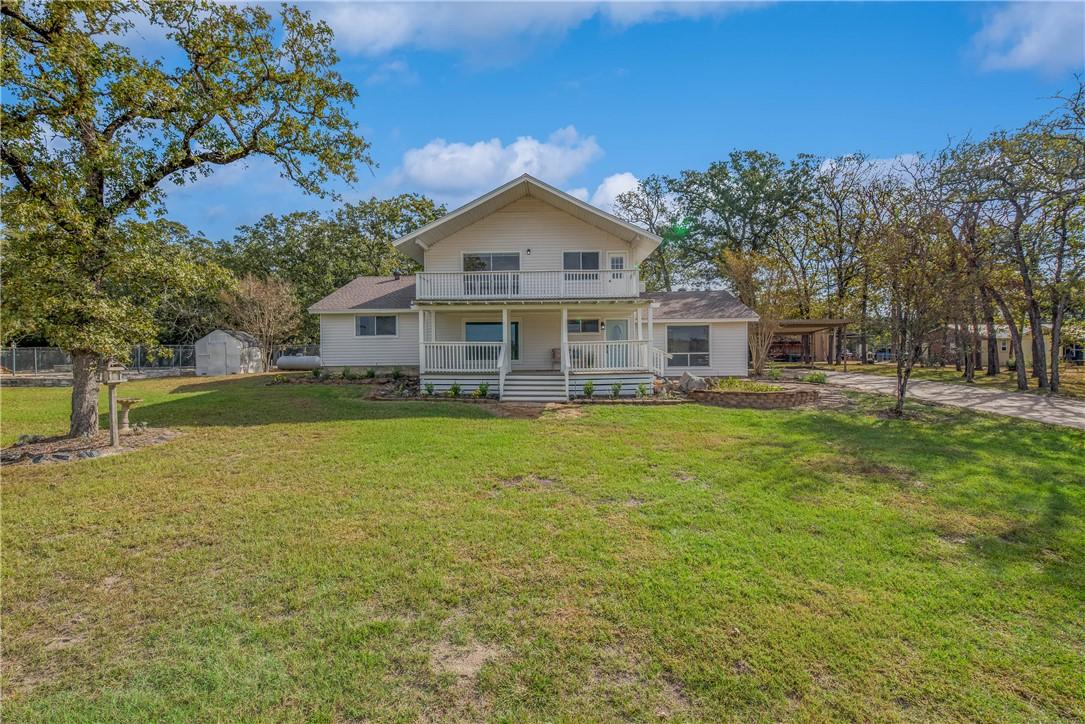 Image 2: View of front of home with a balcony, a front yard
