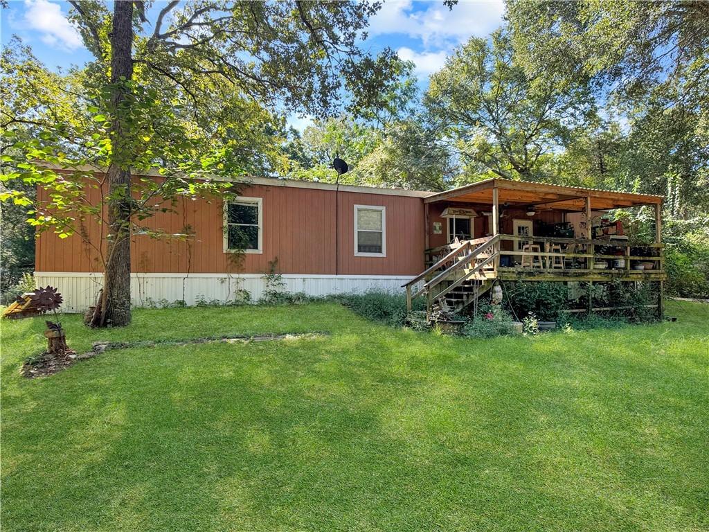 Image 3: Rear view of property with stairway, a lawn, and a