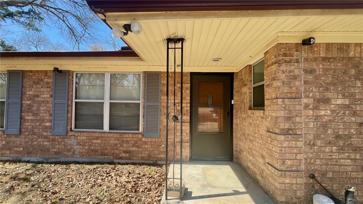 Image 4: View of exterior entry featuring brick siding