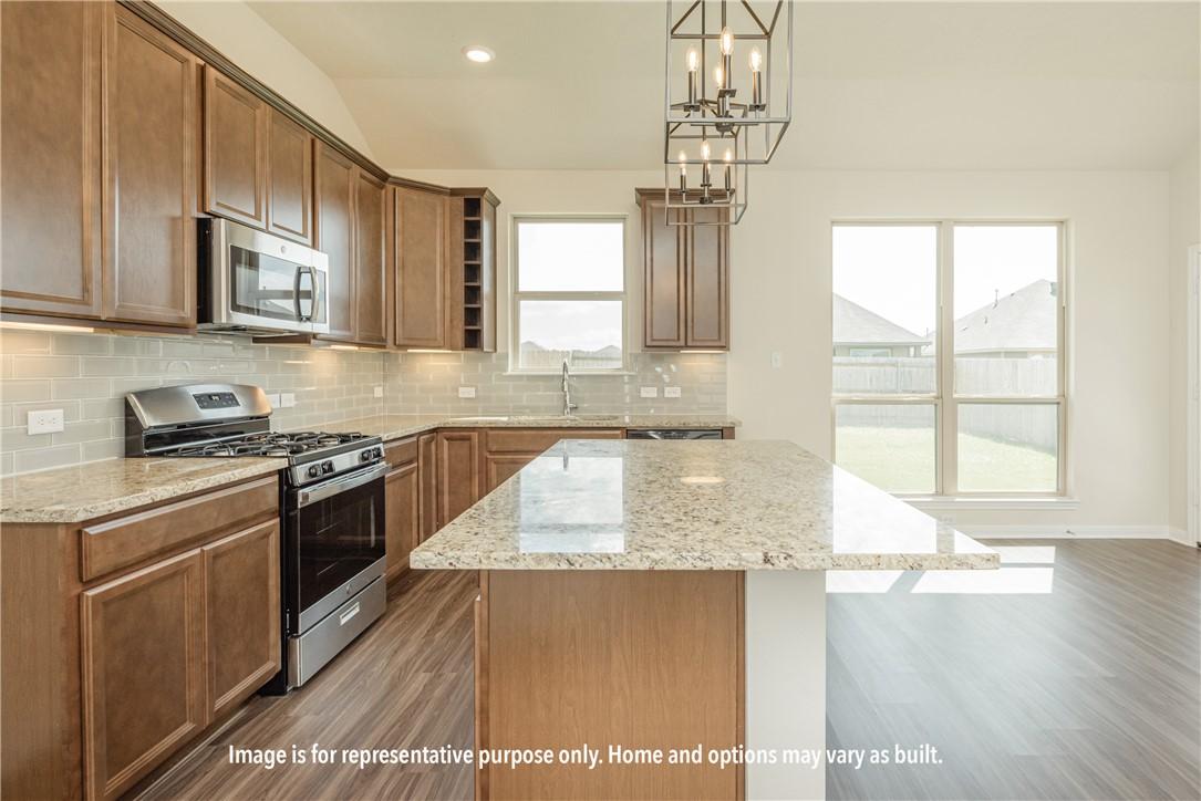 Image 2: Kitchen with tasteful backsplash, lofted ceiling,