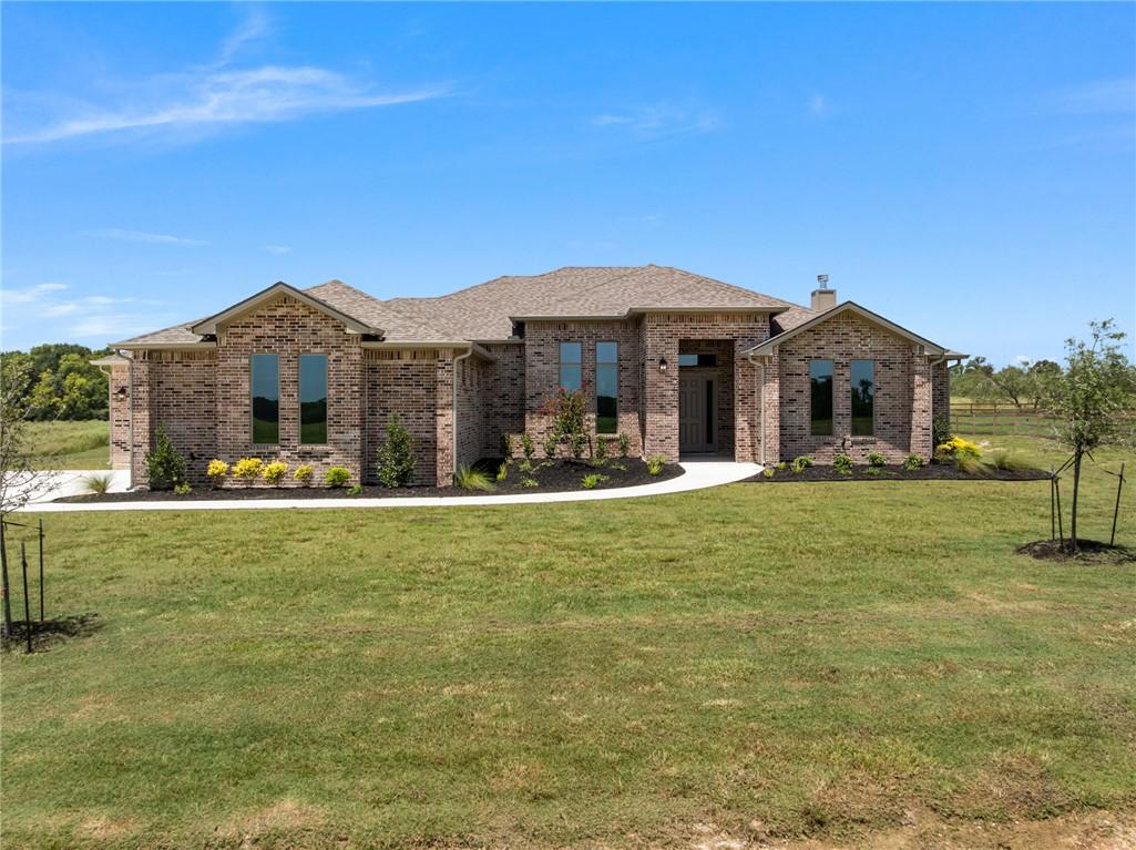 Image 3: View of front facade with brick siding, a front la