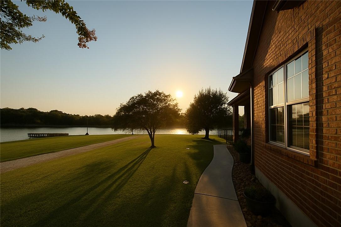 Image 2: View of community with a water view and a yard