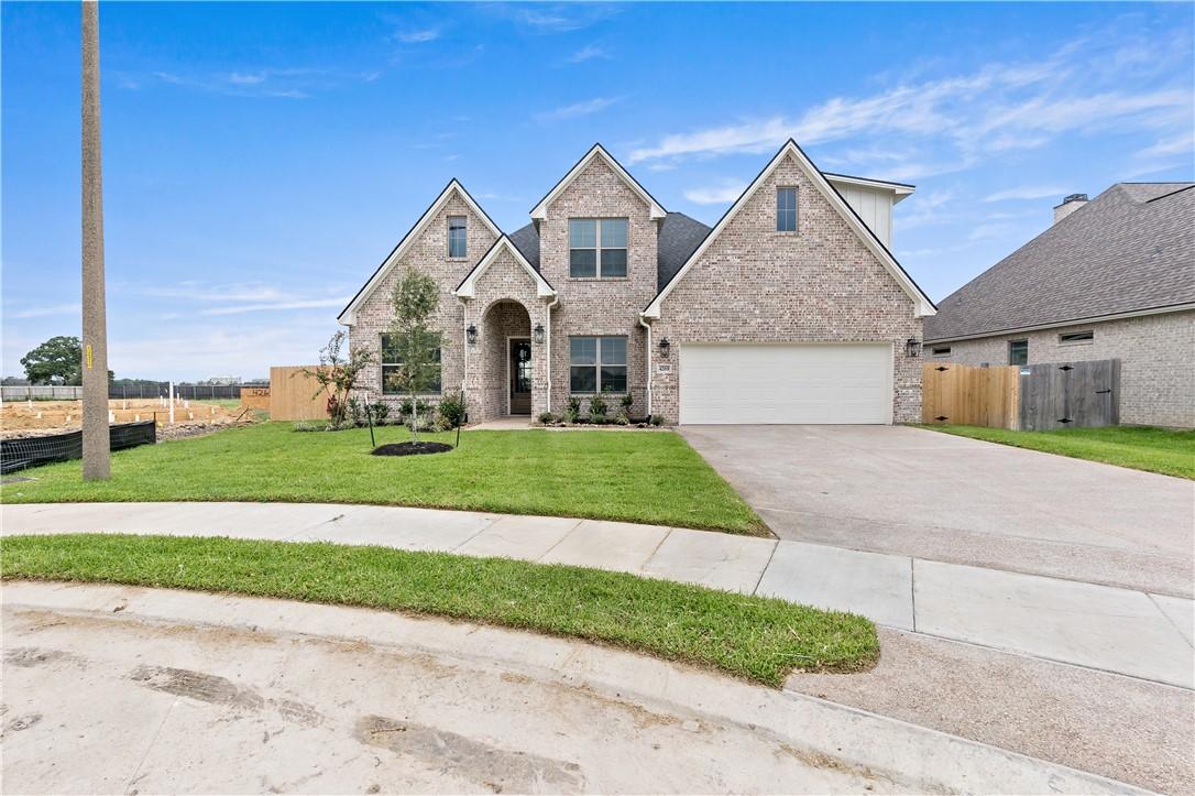 Image 1: View of front facade with driveway and brick sidin