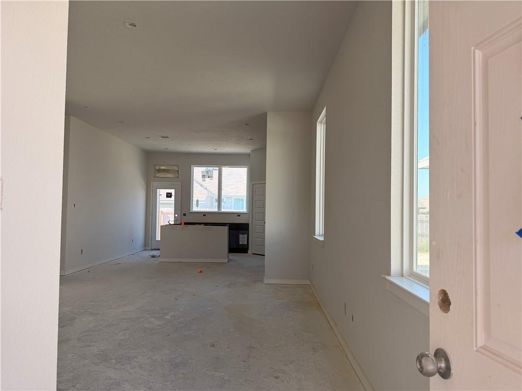 Image 2: Corridor featuring baseboards and unfinished concr