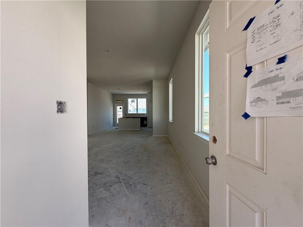 Image 3: Corridor with baseboards and concrete floors