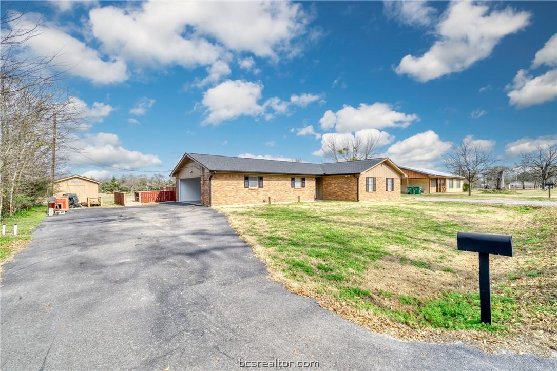 Image 2: Ranch-style home with brick siding, an attached ga