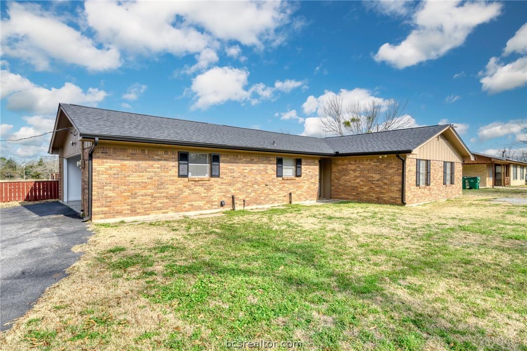Image 4: Front of house with a lawn, driveway, brick siding