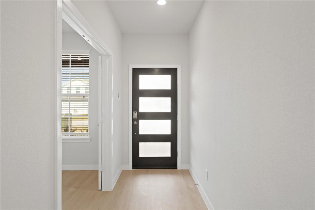Image 4: Doorway featuring wood finished floors and baseboa