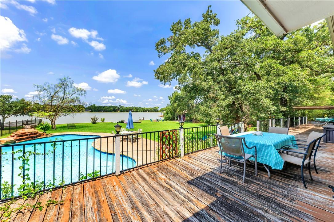 Image 1: Wooden deck featuring a water view, a yard, and ou