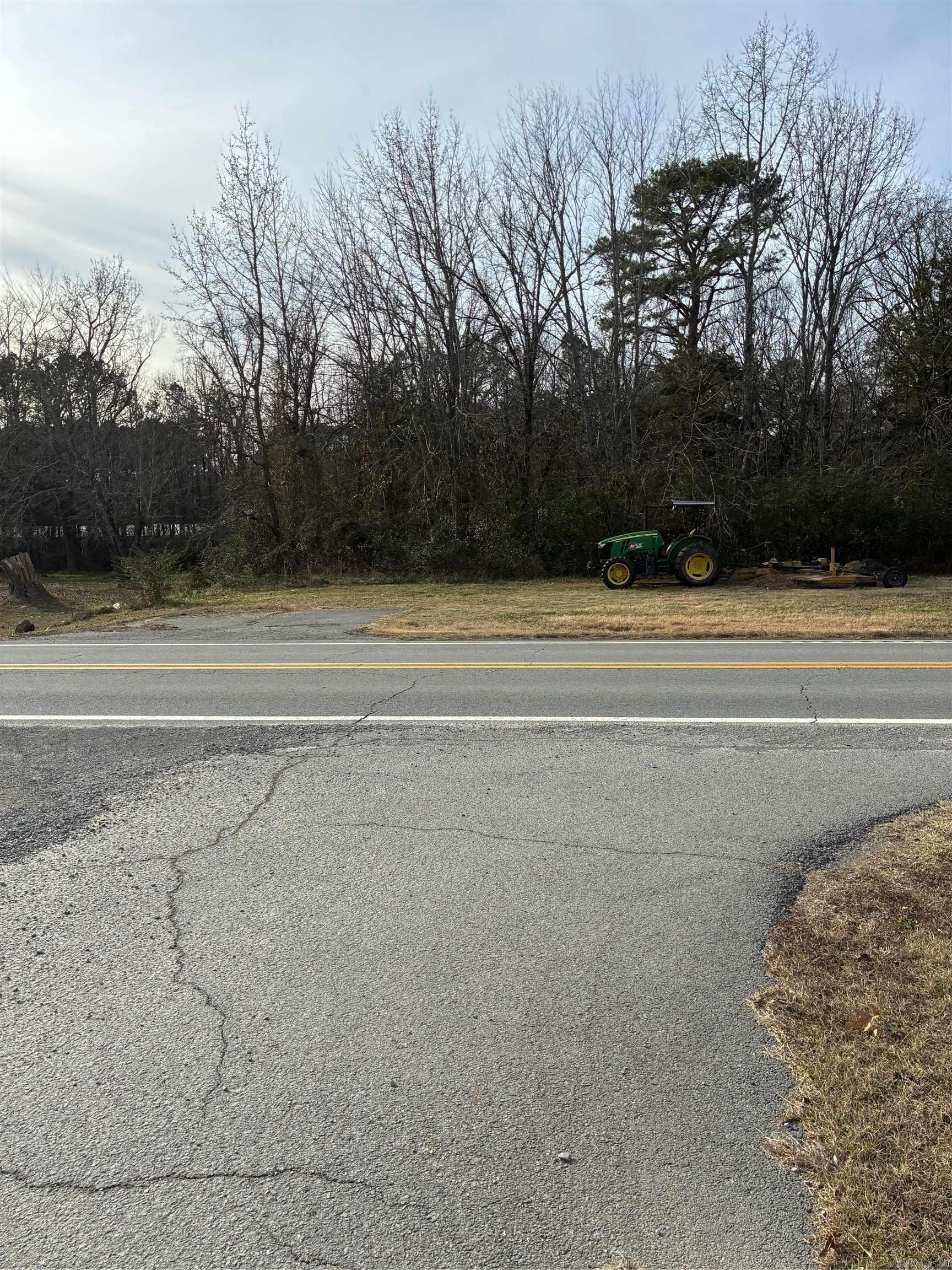 Image 0: The lot is in the wood line behind the tractor