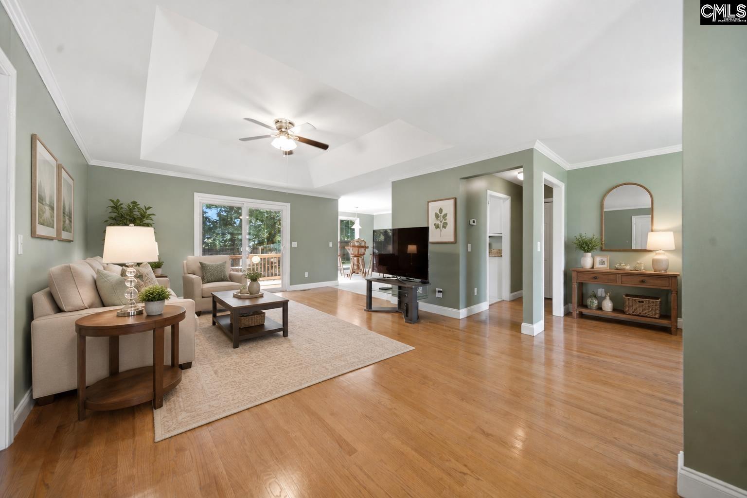 Image 2: Comfortable living room with gleaming hardwood floors, plenty of natural light, and tray ceilings., Living room with AI enhancements.