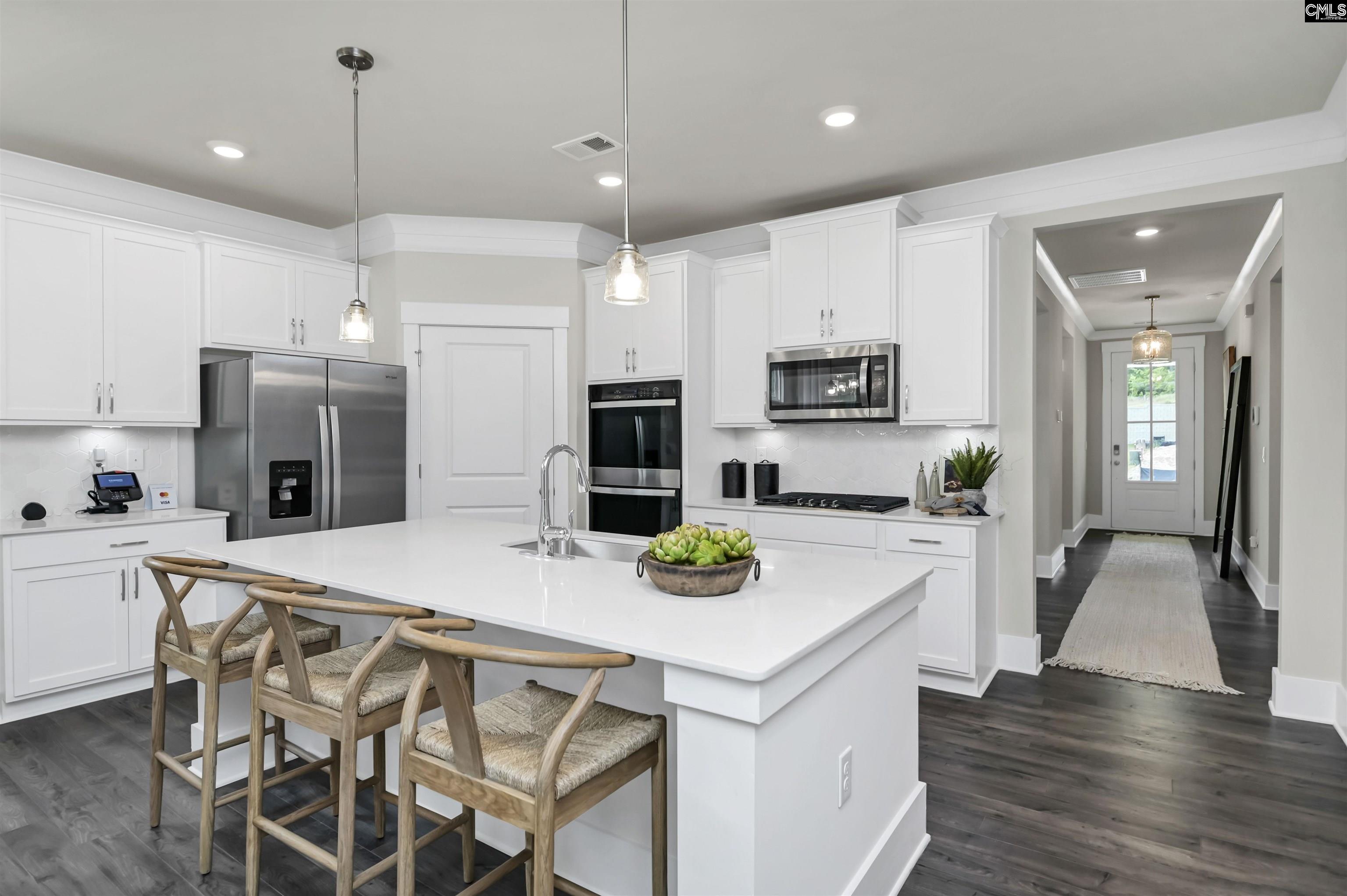 Image 1: Kitchen space opens up at the end of the front foyer