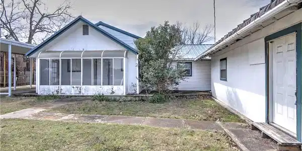 Image 3: Enclosed sun porch leads to main entrance. Side en