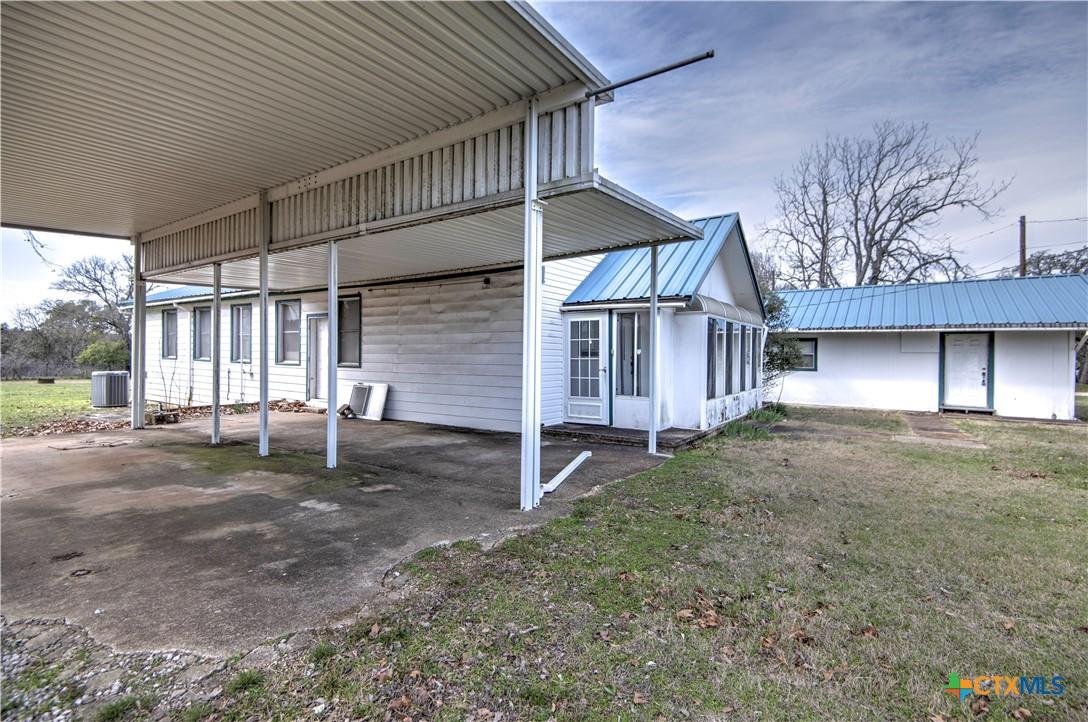 Image 4: 3 concrete carports on side of home.