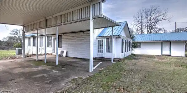 Image 4: 3 concrete carports on side of home.