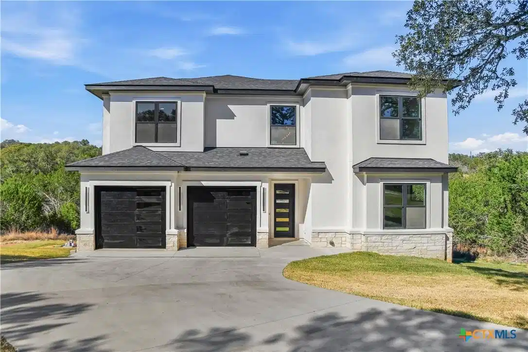 Image 1: On view of the house from the drive way. White stu