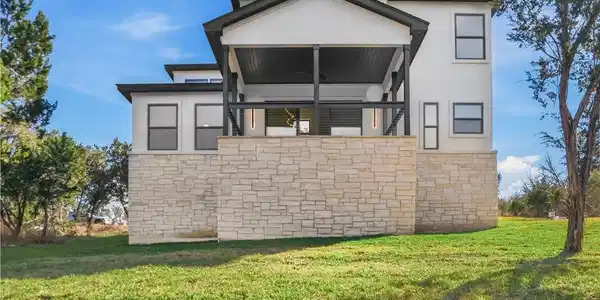 Image 3: Back view of the house from the yard. Featuring a