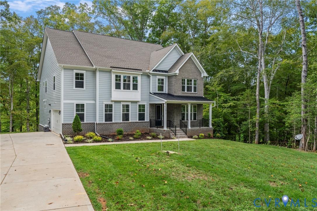 Image 1: View of front of home with covered porch, concrete