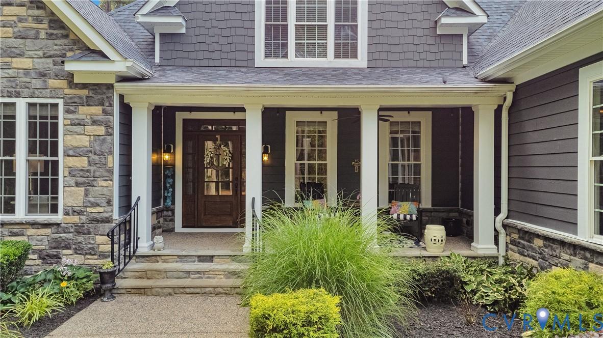 Image 3: Stone and siding exterior featuring a covered fron