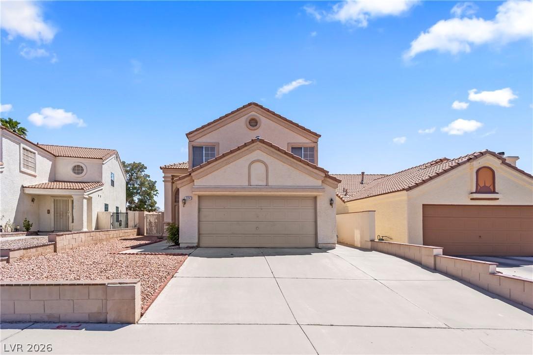 Image 2: This two-story home features a tiled roof and an a