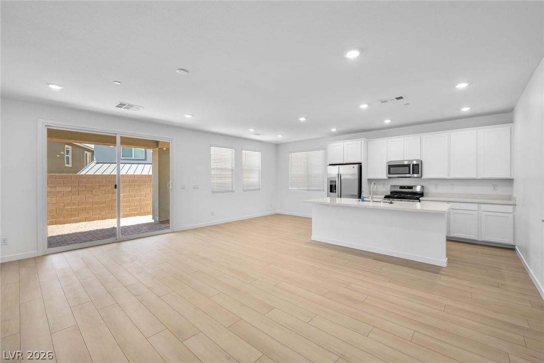 Image 3: An open-concept living area with sleek wooden floo