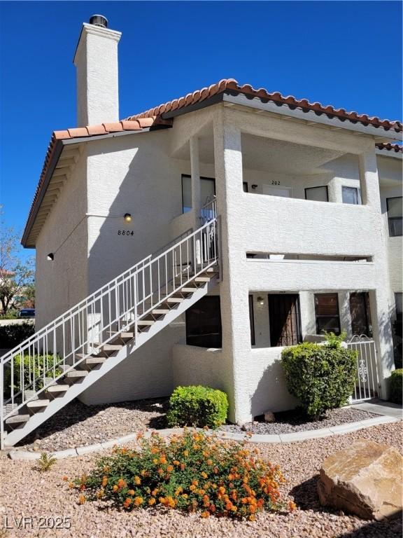 Image 2: View of home's exterior with stairway, a tiled roo