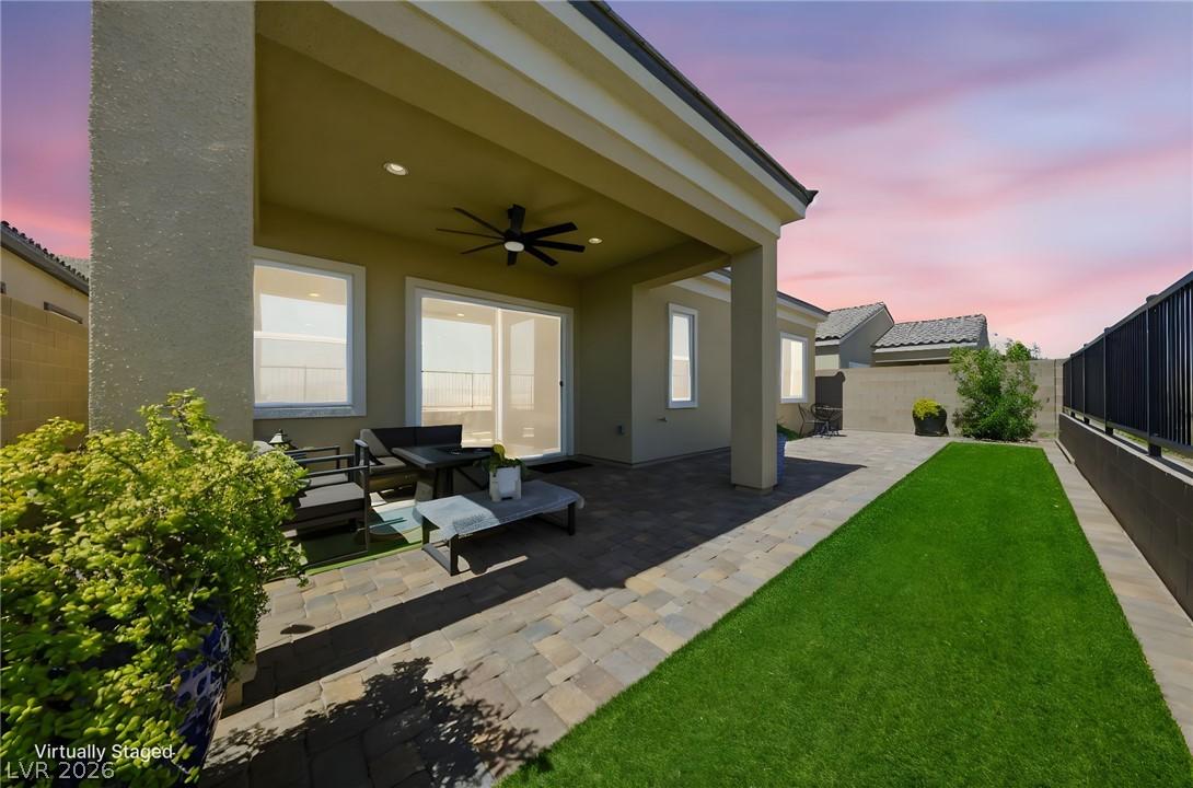 Image 3: A well-lit covered patio and paved yard offer an i