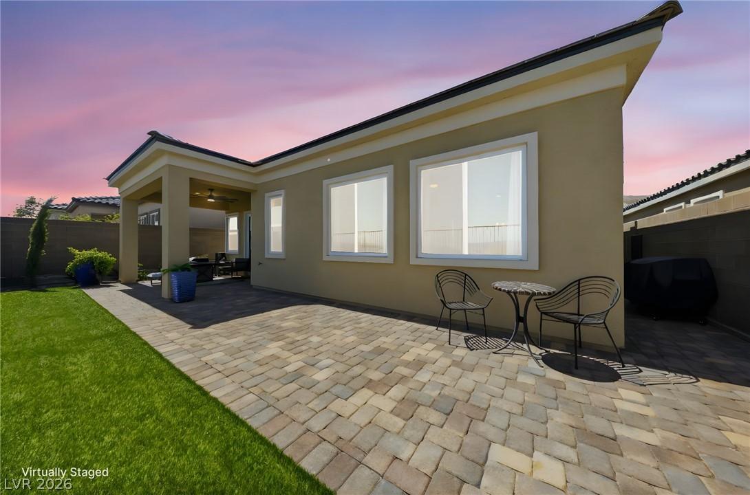 Image 4: An inviting backyard oasis features a paved patio