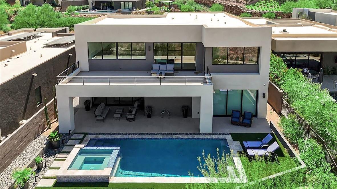 Image 2: Back of property with a patio, outdoor lounge area