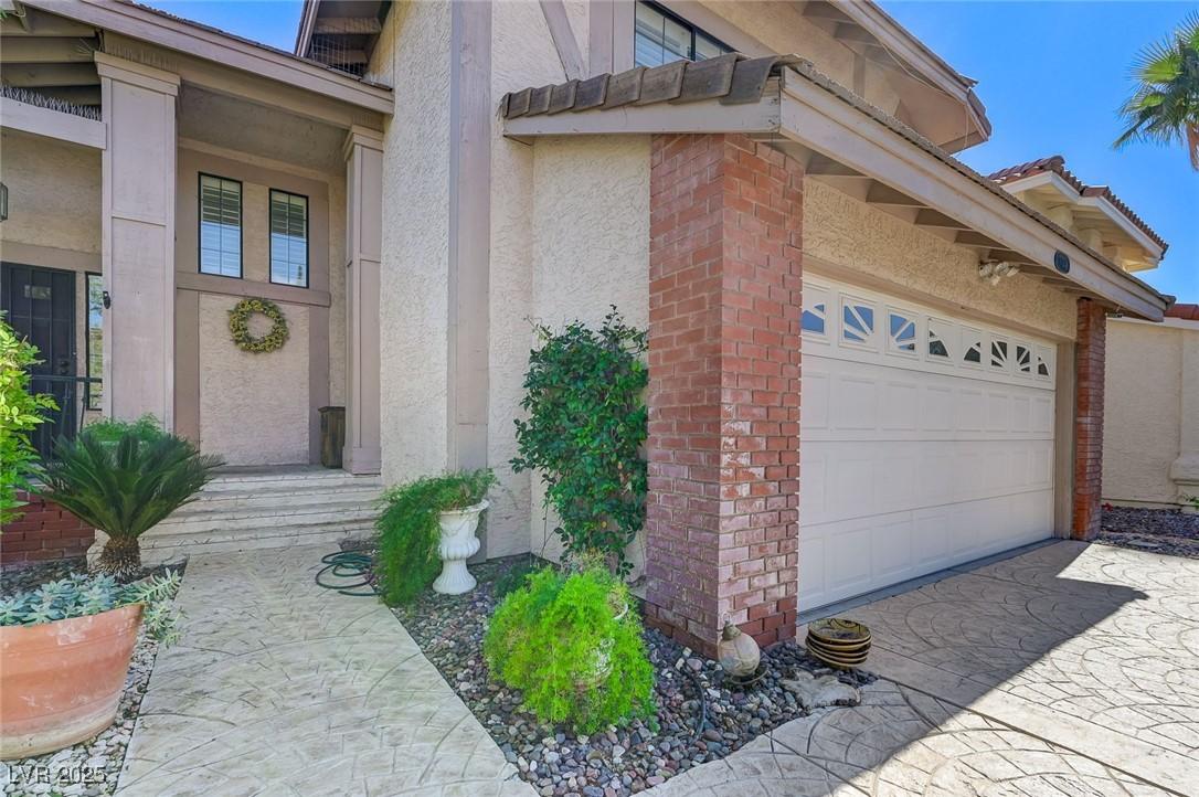 Image 4: View of exterior entry with stucco siding, a tile