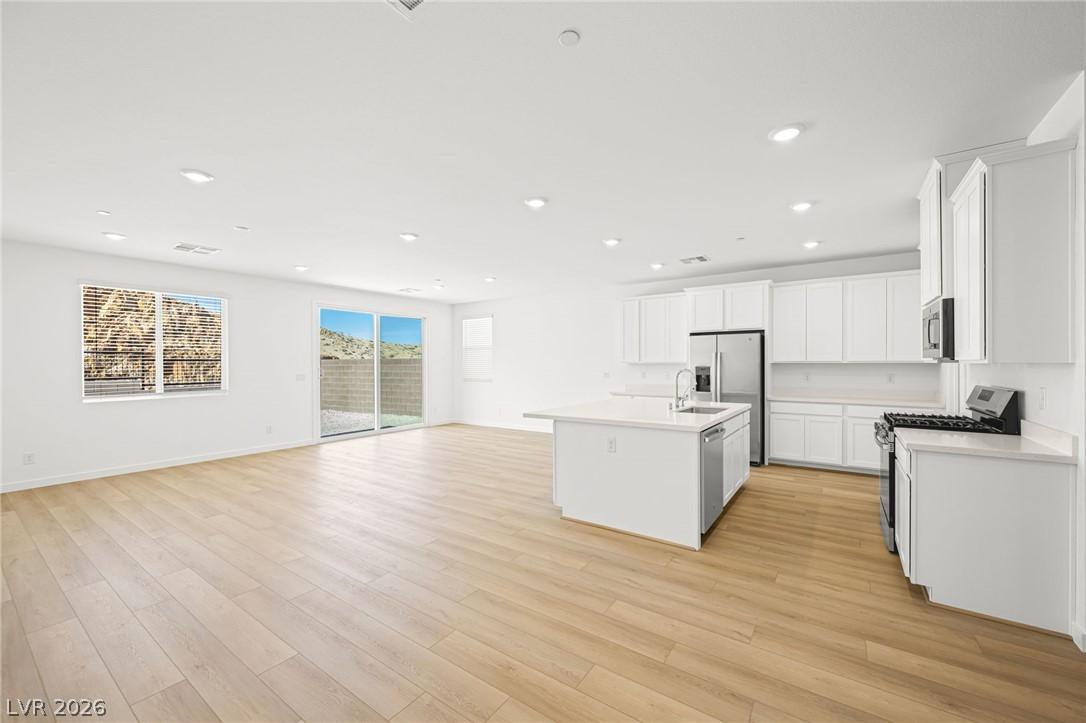 Image 3: An open-concept layout showcases a kitchen island