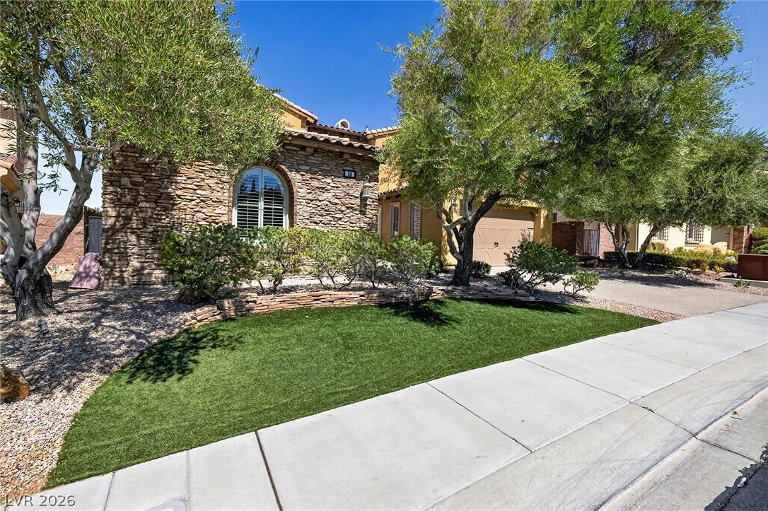 Image 3: A well-manicured front yard with artificial turf c