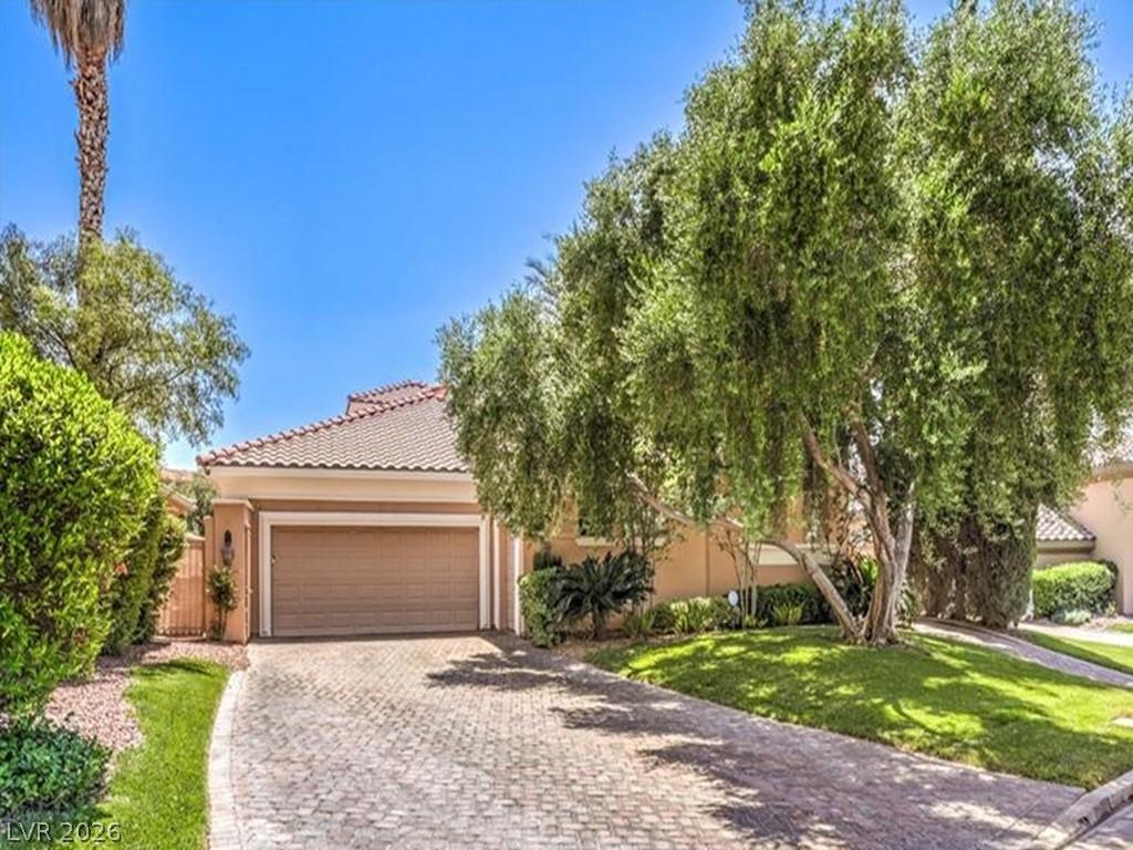 Image 1: This residence features a paver driveway, an attac