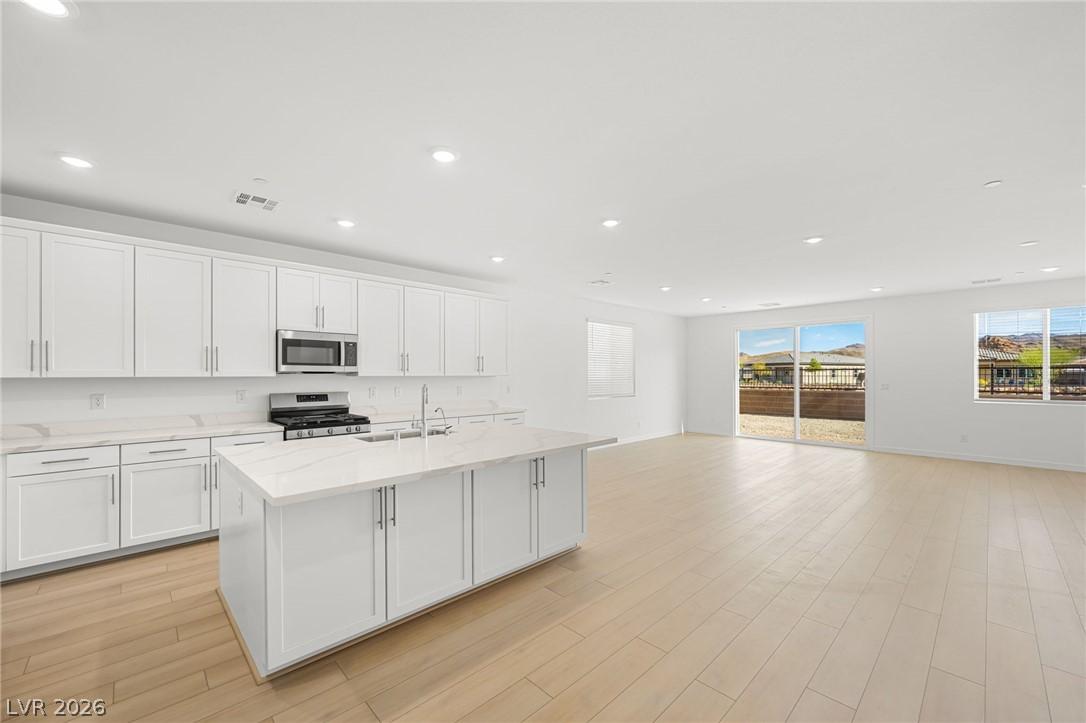 Image 4: A well-lit, open-concept kitchen and living area f