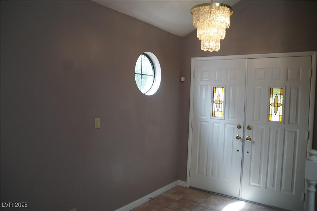 Image 2: Foyer with a chandelier and baseboards