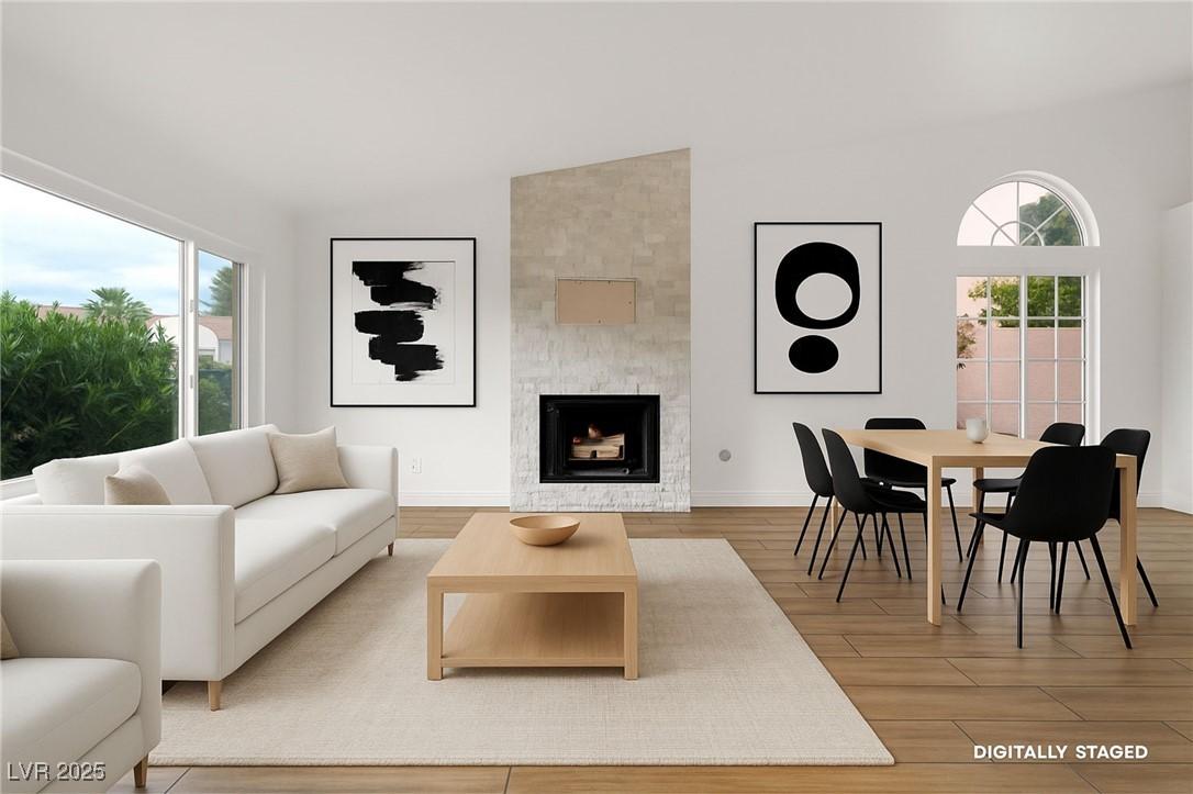 Image 2: Living area with a tile fireplace and light wood-t