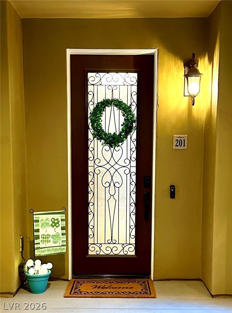 Image 3: A dark-stained entry door features an ornate wroug