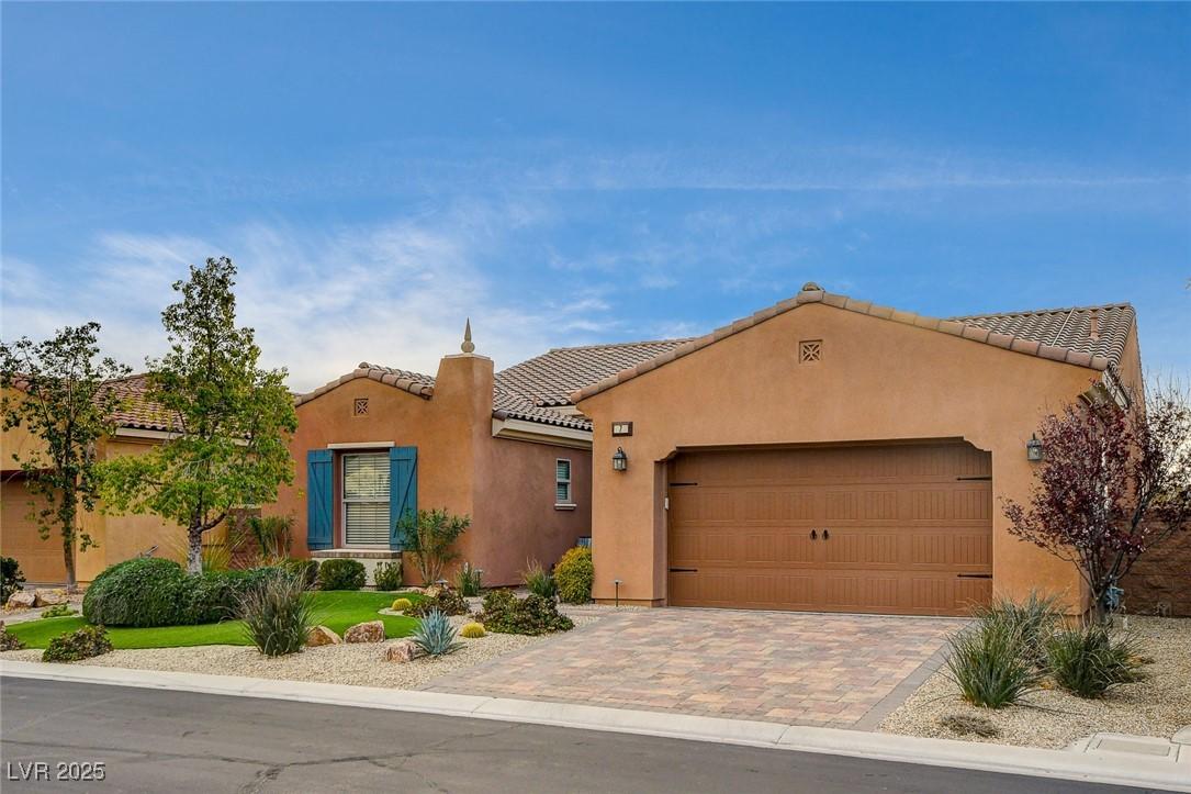 Image 4: View of front of home featuring a tiled roof, a ga